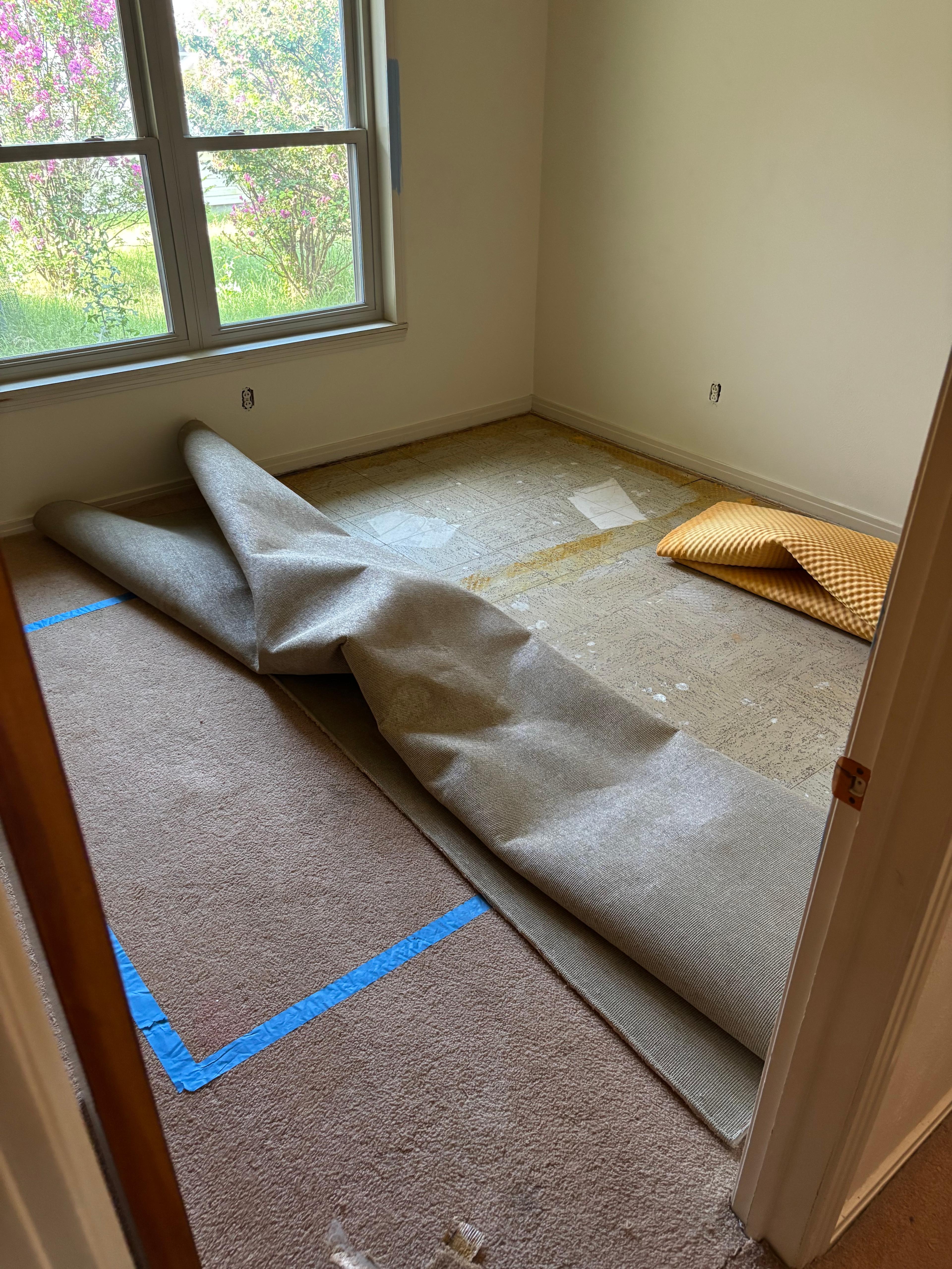 Old carpet and padding pulled back from a doorway during a carpet removal job
