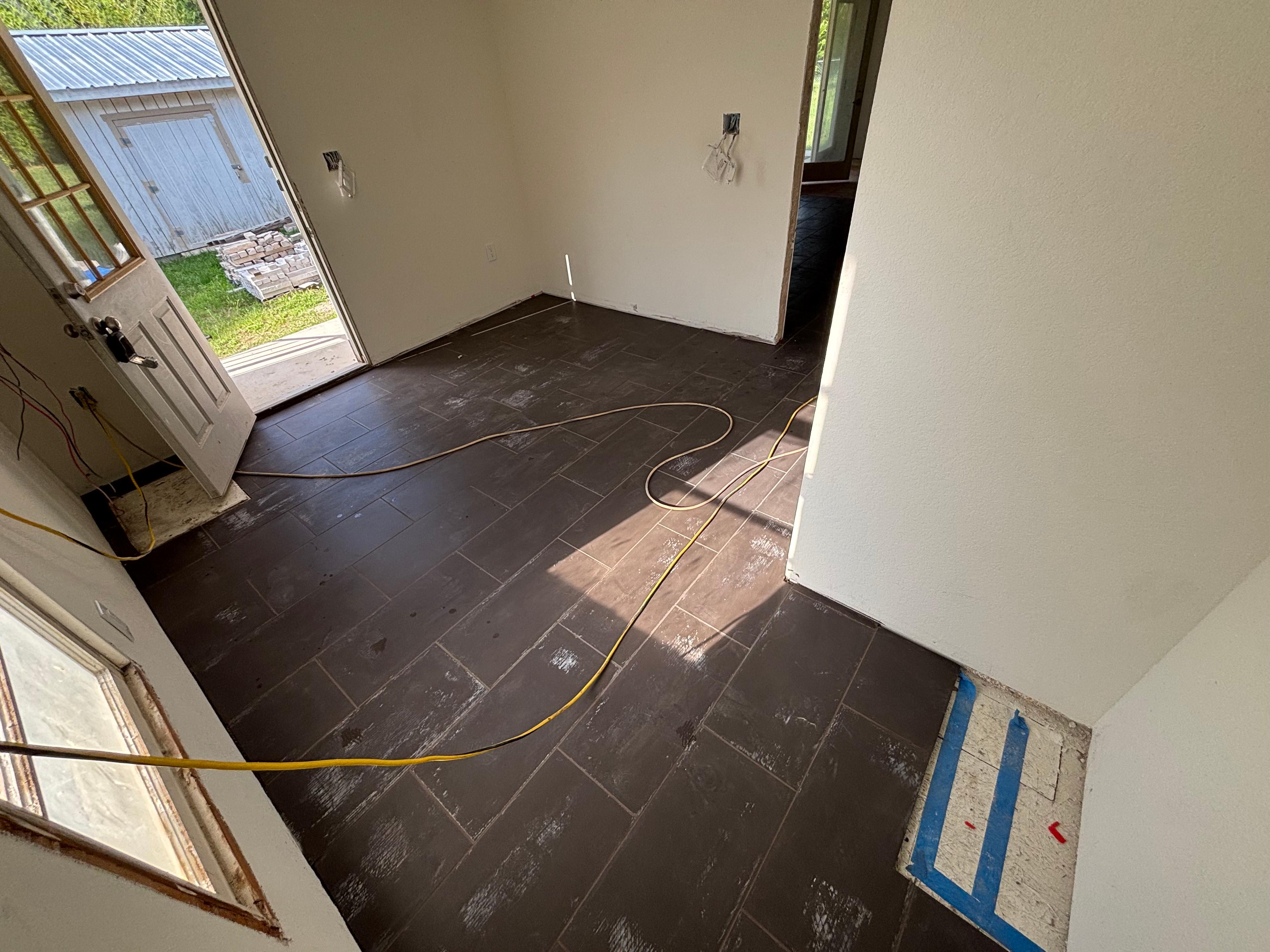 Dark plank-format tile floor installed in a home entryway